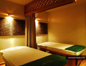 Không gian spa yên tĩnh với hai giường massage, ánh sáng ấm áp tạo cảm giác thư giãn dễ chịu.