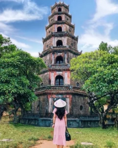 Chùa Thiên Mụ với kiến trúc độc đáo, người tham quan đứng trước cảnh đẹp yên bình.