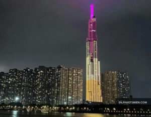 Landmark 81 chiếu sáng ban đêm với ánh đèn nhiều màu sắc, nổi bật giữa các tòa nhà xung quanh.