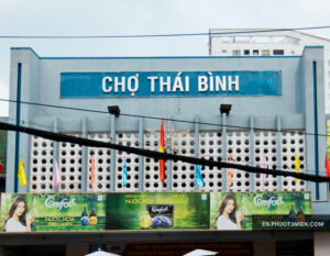 Chợ Thái Bình với biển hiệu rõ ràng và các quảng cáo trên tường.